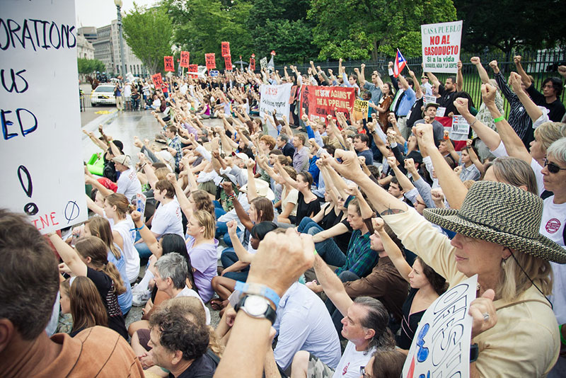 Climate organizers raise their fists in direct action at the White House