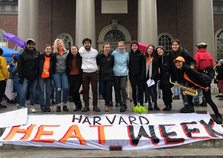 Young campus fossil fuel divestment activists pose with a banner that says "Harvard Heat Week".