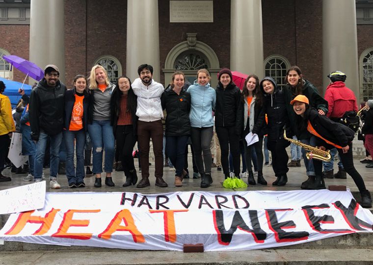 Young campus fossil fuel divestment activists pose with a banner that says "Harvard Heat Week".