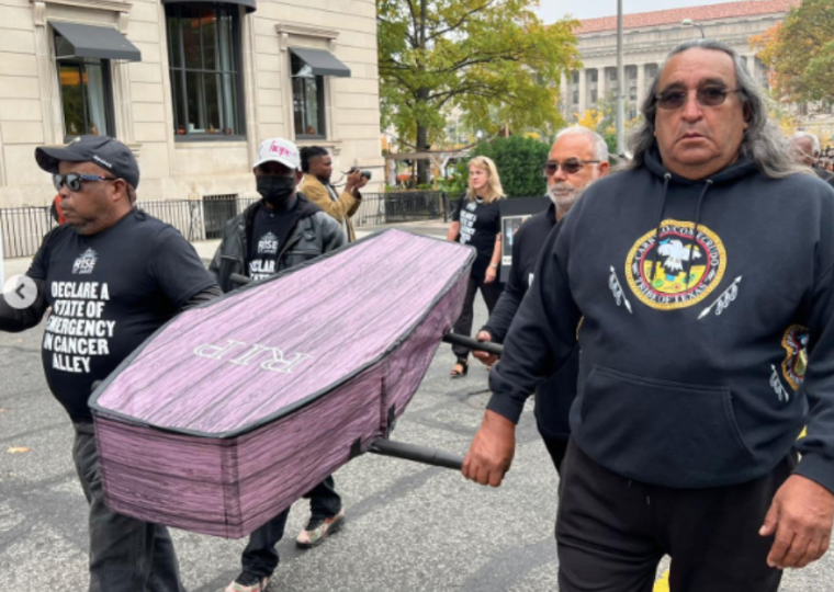 Folks are holding a light purple colored casket that says RIP. " title="Folks are holding a light purple colored casket that says RIP.