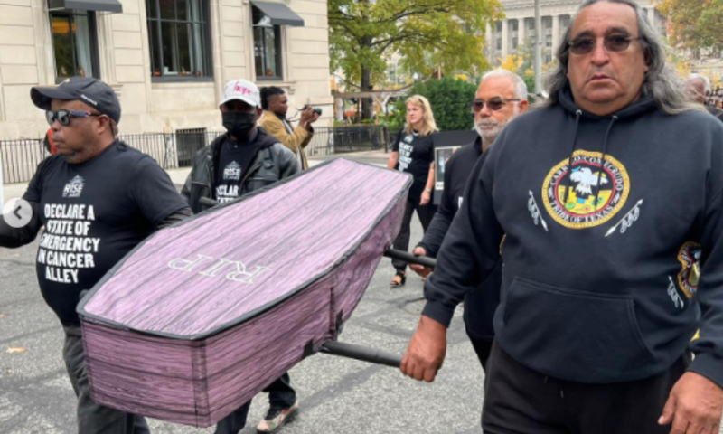 Folks are holding a light purple colored casket that says RIP. " title="Folks are holding a light purple colored casket that says RIP.